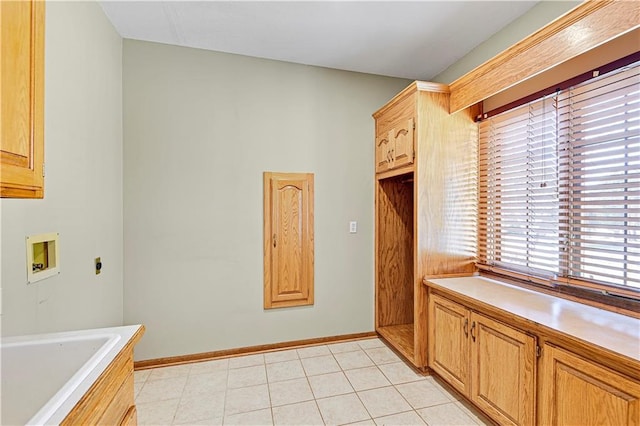 kitchen with light countertops, light tile patterned flooring, and baseboards