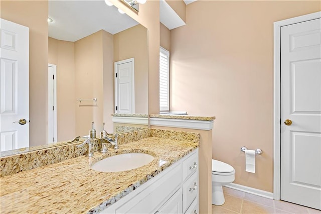 bathroom with tile patterned flooring, toilet, vanity, and baseboards