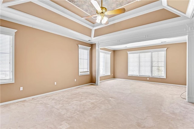 carpeted spare room with crown molding, plenty of natural light, baseboards, and a raised ceiling