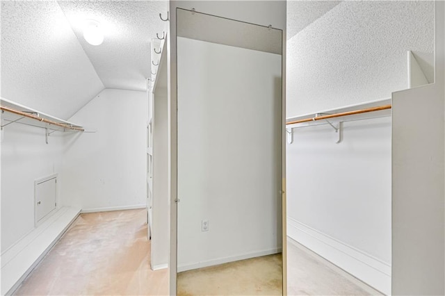 walk in closet with carpet flooring and lofted ceiling