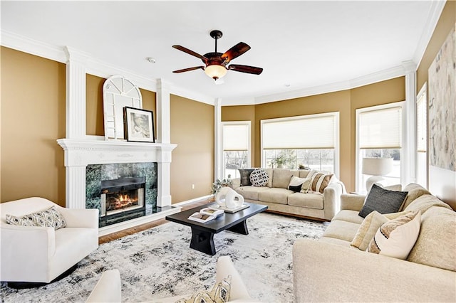 living room featuring a ceiling fan, crown molding, wood finished floors, and a high end fireplace