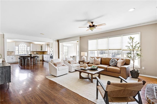 living room featuring ceiling fan, baseboards, ornamental molding, recessed lighting, and dark wood-style flooring