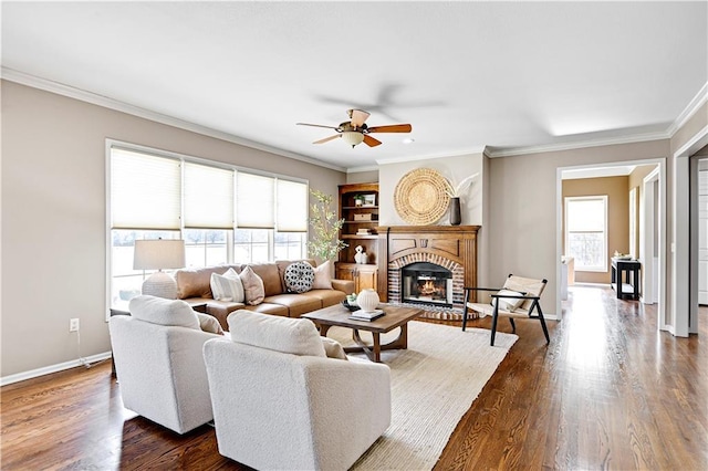 living area with baseboards, a fireplace, dark wood-style floors, and crown molding