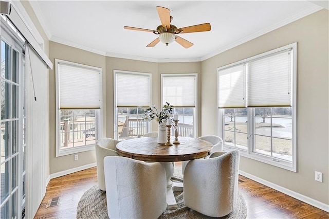 dining area featuring crown molding, wood finished floors, visible vents, and baseboards