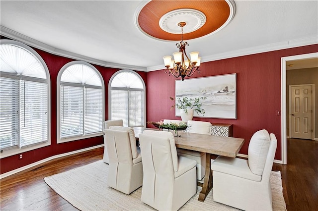 dining room with wood finished floors, visible vents, a chandelier, and ornamental molding