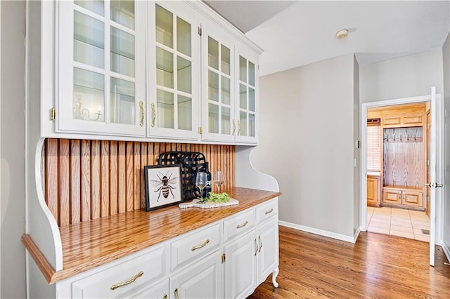 bar featuring baseboards and light wood-style floors