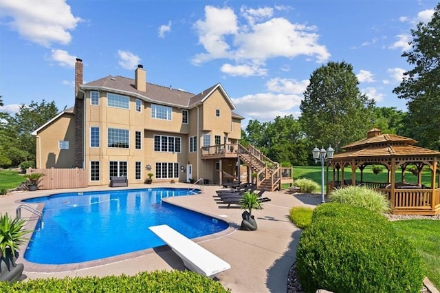 outdoor pool featuring a patio, fence, a diving board, stairs, and a gazebo