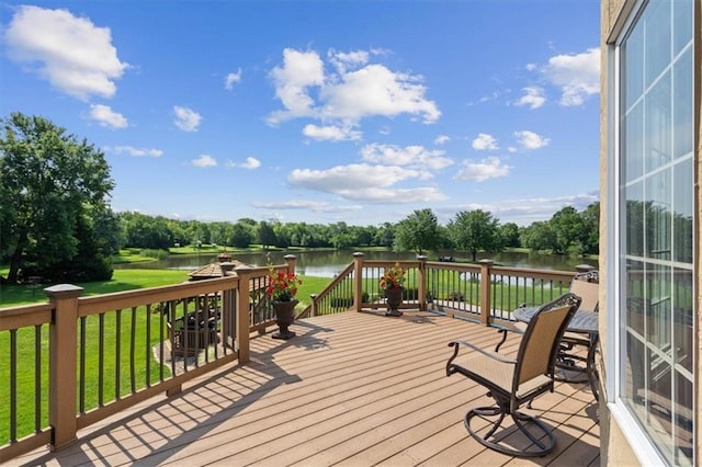 wooden terrace featuring a water view and a lawn