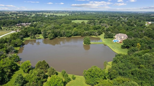 drone / aerial view with a wooded view and a water view