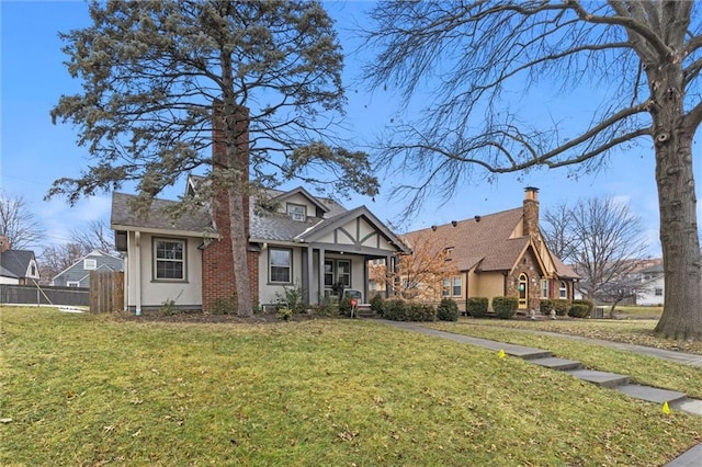 tudor-style house featuring a porch and a front lawn