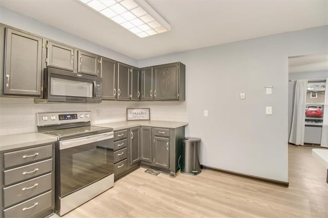 kitchen featuring tasteful backsplash, gray cabinetry, electric range, and light hardwood / wood-style floors