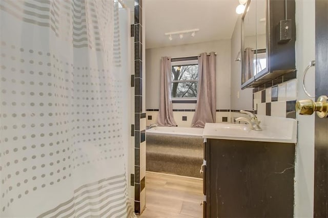 bathroom featuring hardwood / wood-style flooring, vanity, and shower / bath combo