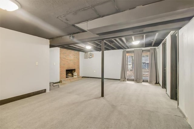 basement featuring light colored carpet and a fireplace