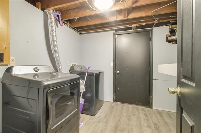 washroom with independent washer and dryer and light wood-type flooring