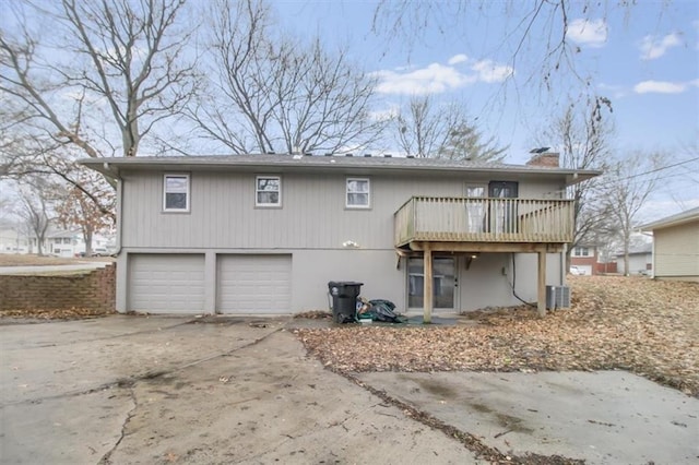 rear view of house featuring a garage, a balcony, and cooling unit