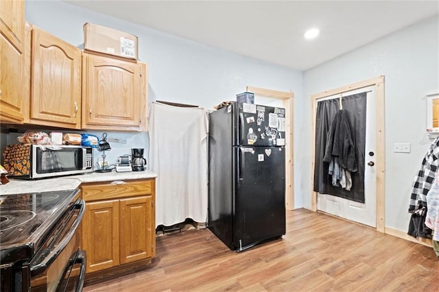 kitchen featuring light wood-style flooring, stainless steel appliances, light countertops, and recessed lighting