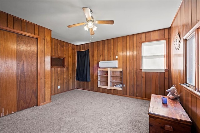 bedroom featuring ceiling fan, wooden walls, a closet, and light colored carpet