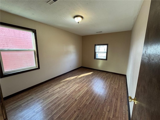 empty room featuring hardwood / wood-style floors and a textured ceiling