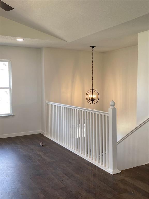 123 NW 171st Rd, Warrensburg, MO 64093 - spare room with wood finished floors, lofted ceiling, baseboards, and a chandelier