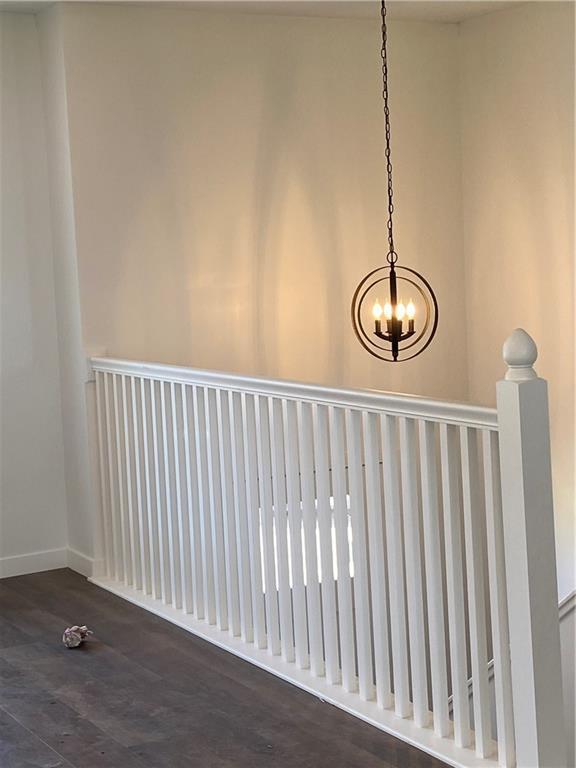 123 NW 171st Rd, Warrensburg, MO 64093 - detailed view of wood finished floors, a chandelier, and baseboards