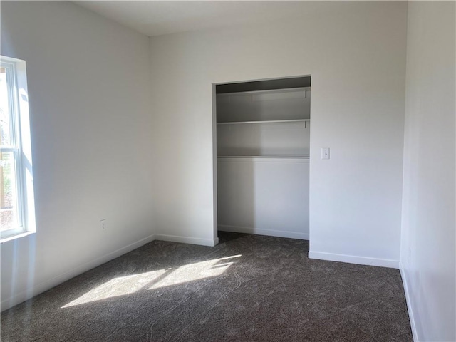 123 NW 171st Rd, Warrensburg, MO 64093 - unfurnished bedroom featuring dark carpet, a closet, and baseboards