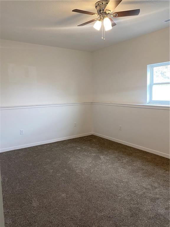 123 NW 171st Rd, Warrensburg, MO 64093 - spare room with dark carpet, a ceiling fan, and baseboards