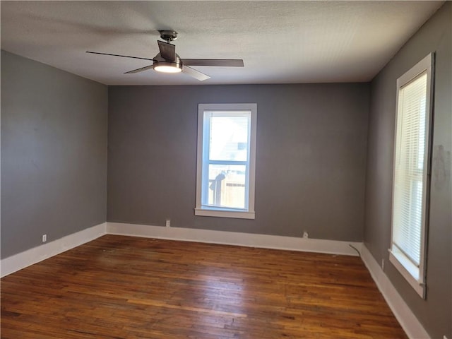 empty room featuring a ceiling fan, a textured ceiling, baseboards, and wood finished floors