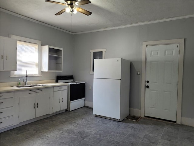 kitchen featuring electric range, white cabinets, ornamental molding, freestanding refrigerator, and a sink