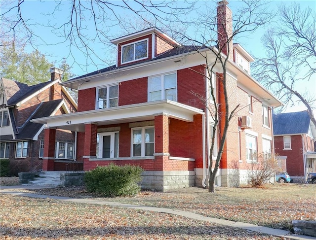 view of front facade featuring a porch and a wall mounted AC