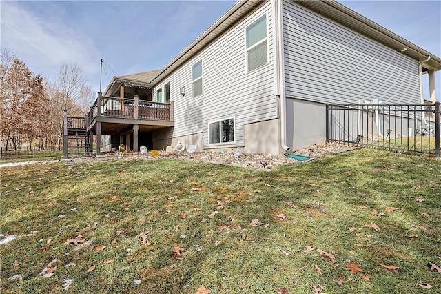 view of side of home with a wooden deck and a yard