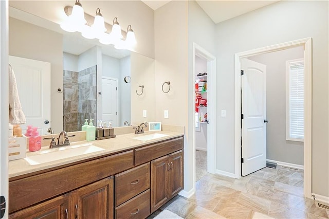 bathroom with vanity and a tile shower