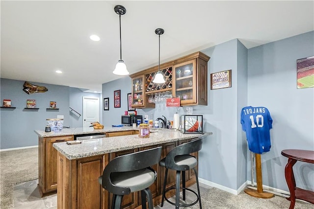 bar with pendant lighting, light carpet, and light stone countertops