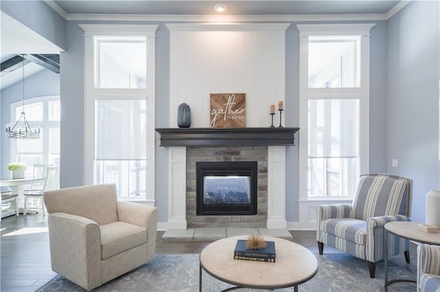 living area with wood finished floors, a glass covered fireplace, and a healthy amount of sunlight