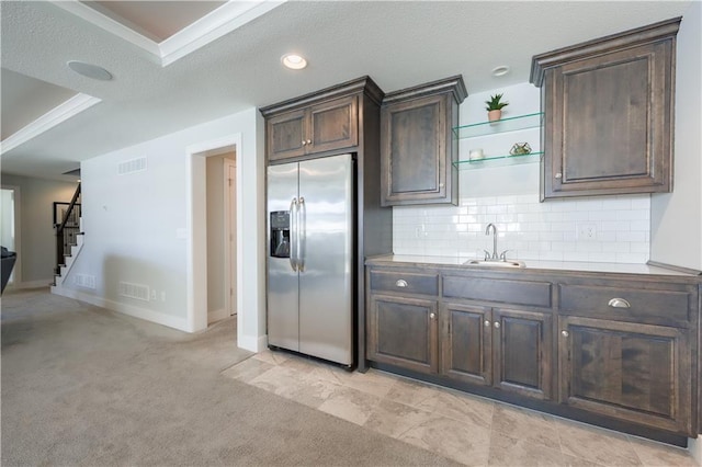 kitchen with dark brown cabinetry, visible vents, a sink, and stainless steel fridge with ice dispenser