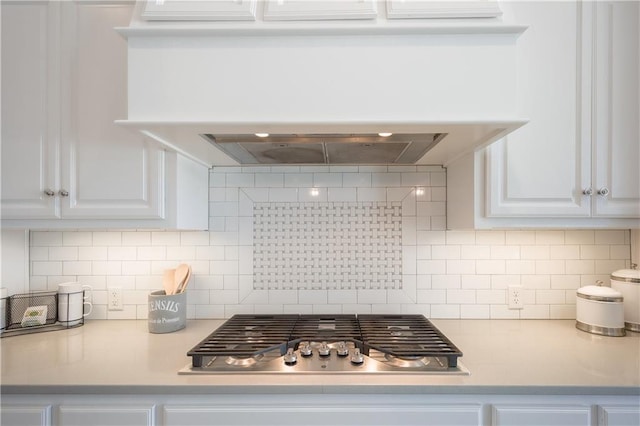 kitchen featuring stainless steel gas cooktop, light countertops, backsplash, and white cabinets