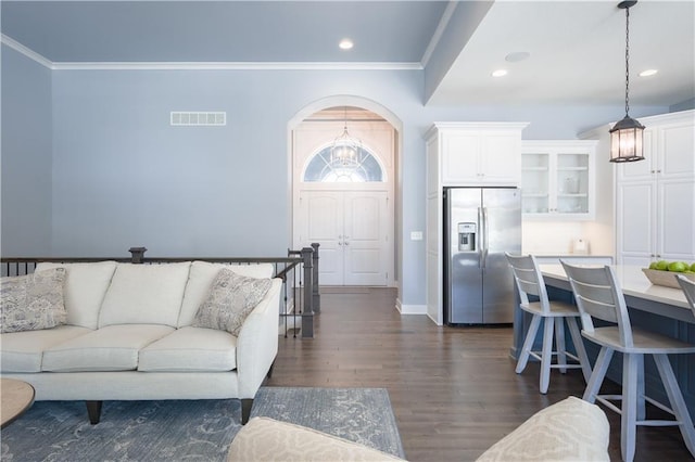 living area with arched walkways, crown molding, recessed lighting, visible vents, and dark wood-type flooring