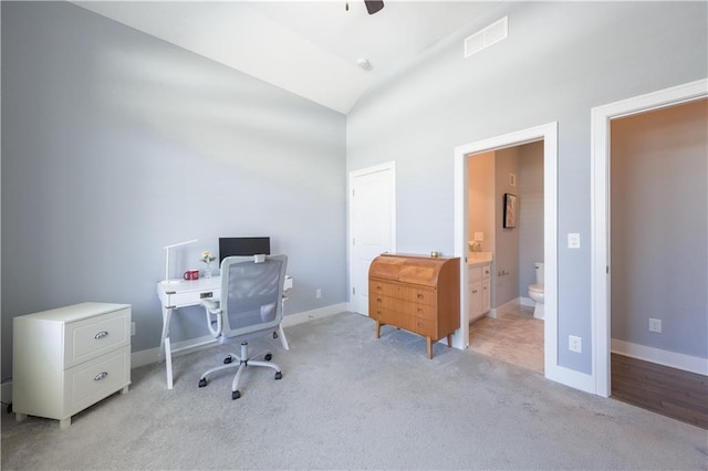 office area featuring high vaulted ceiling, visible vents, baseboards, and light colored carpet