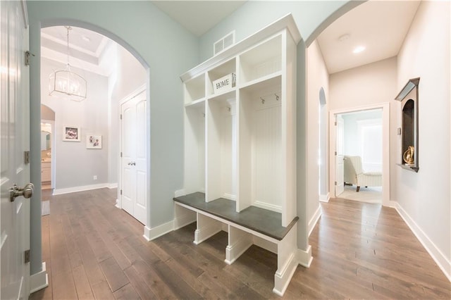 mudroom featuring arched walkways, visible vents, a notable chandelier, and wood finished floors