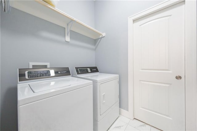 laundry room featuring laundry area, marble finish floor, and independent washer and dryer