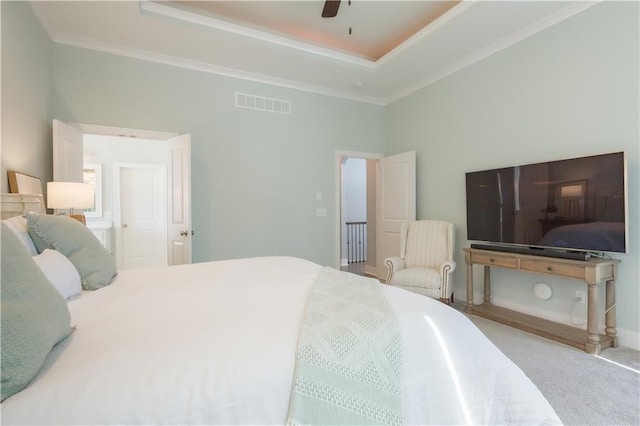 carpeted bedroom with visible vents, a raised ceiling, a ceiling fan, and ornamental molding