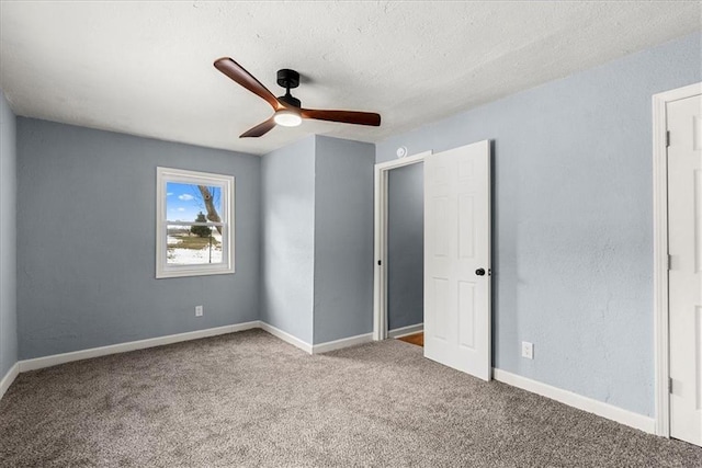 unfurnished bedroom featuring ceiling fan, carpet floors, and a textured ceiling