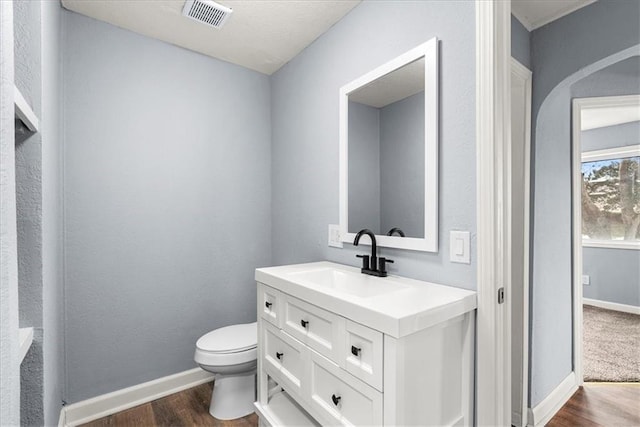 bathroom with vanity, hardwood / wood-style flooring, and toilet