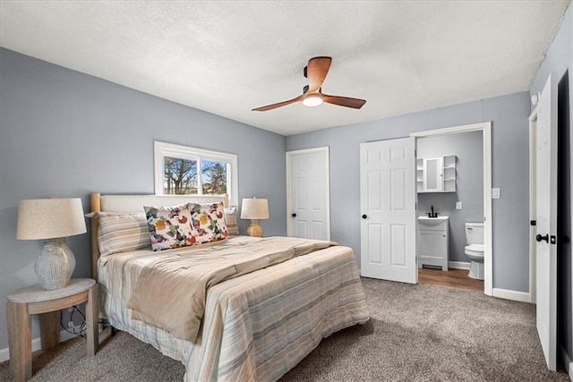 bedroom featuring connected bathroom, sink, carpet, ceiling fan, and a textured ceiling