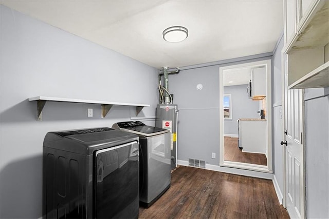 laundry area with water heater, dark hardwood / wood-style floors, and washer and clothes dryer