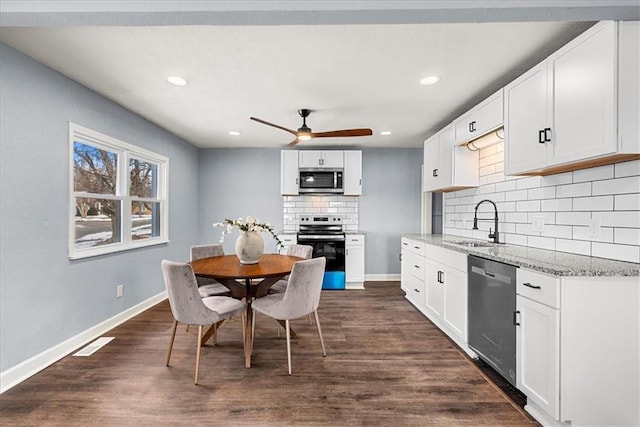 kitchen featuring white cabinetry, stainless steel appliances, sink, and light stone counters