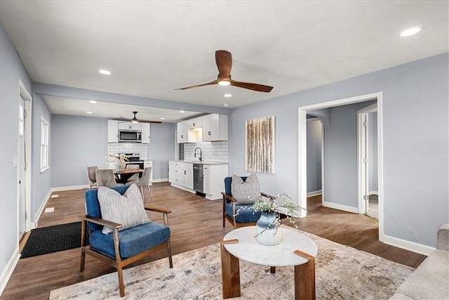 living room with sink, hardwood / wood-style floors, and ceiling fan