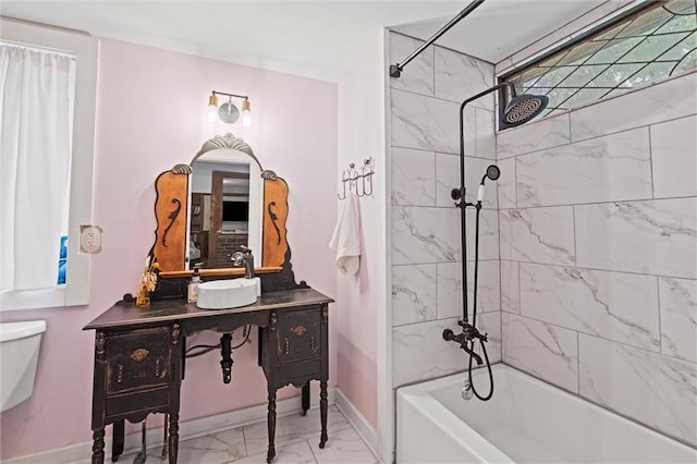 full bathroom with tiled shower / bath, vanity, and toilet