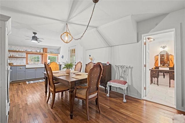 dining area with hardwood / wood-style flooring, ceiling fan, and sink