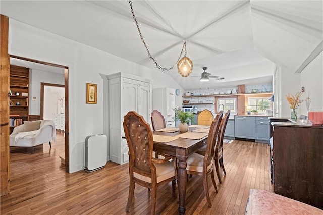 dining space featuring vaulted ceiling, ceiling fan, and light hardwood / wood-style flooring