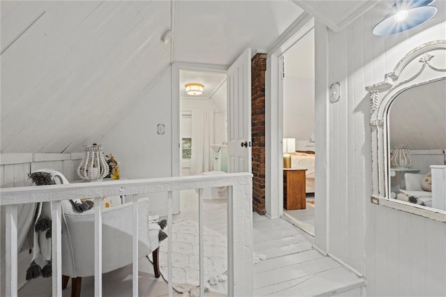 interior space with vaulted ceiling and wood walls